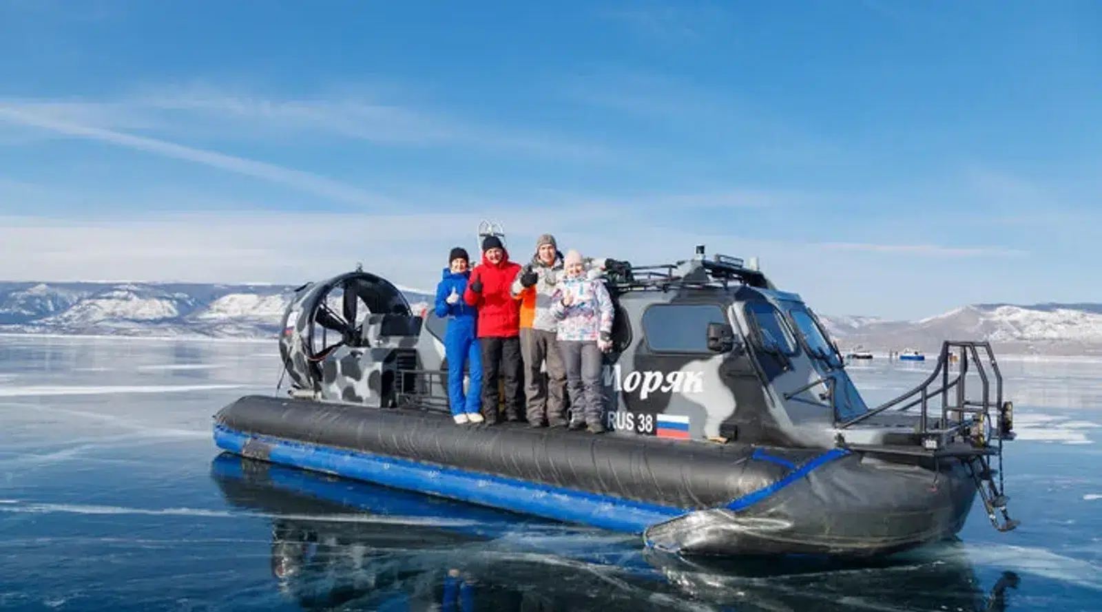 Travelers beside a hovercraft on the frozen lake