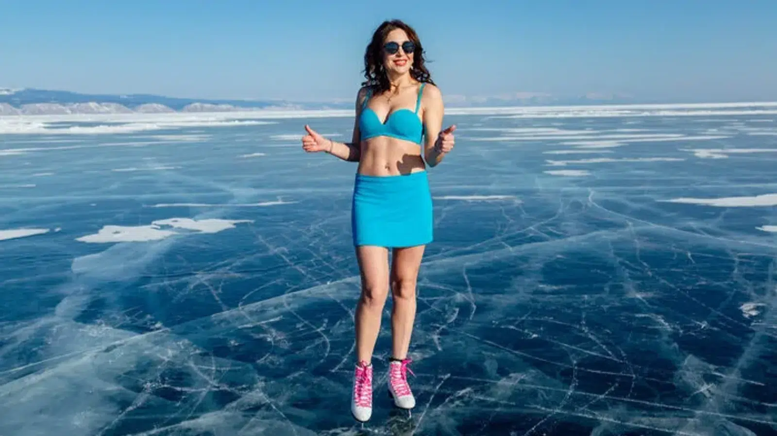 A traveler standing on the clear winter ice of Lake Baikal