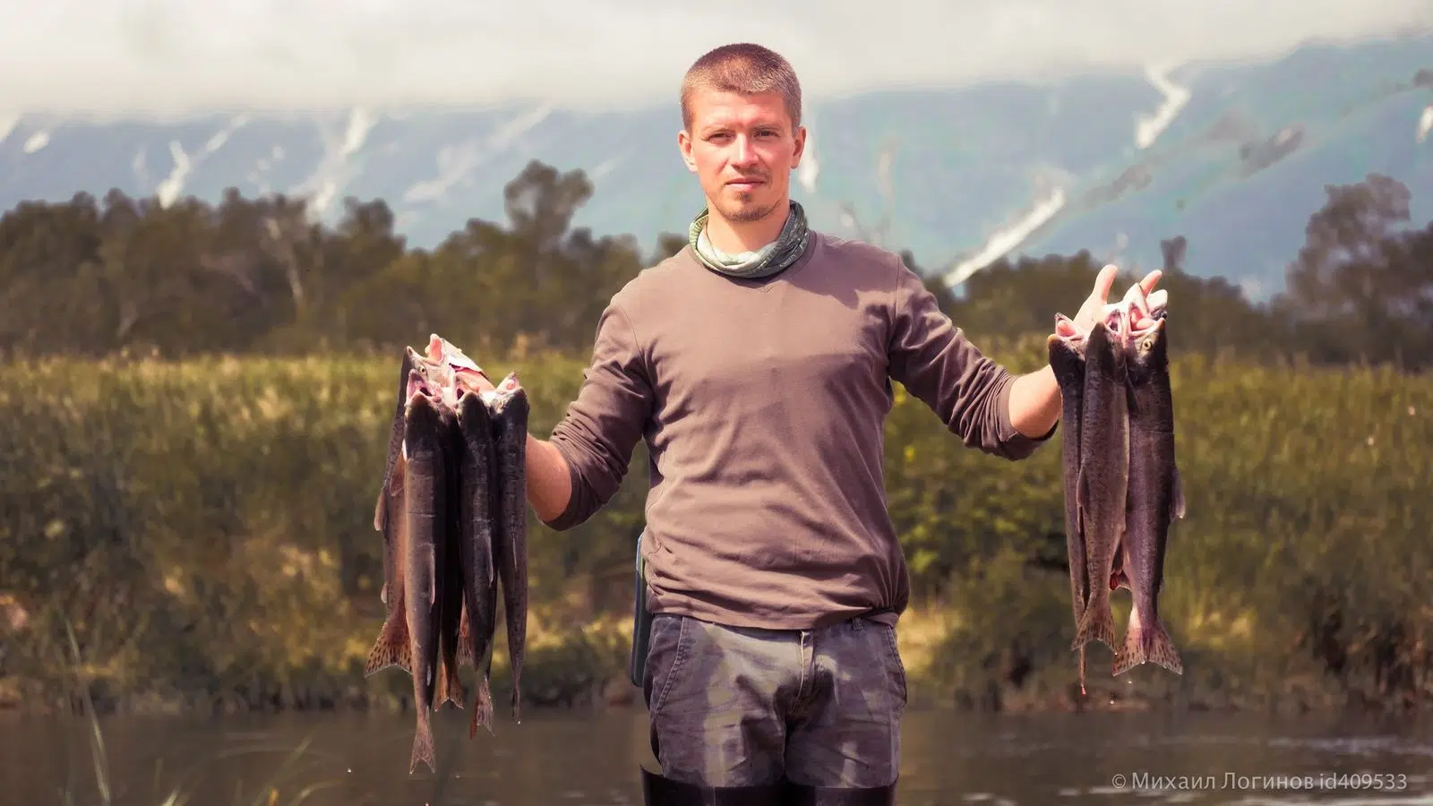 A fisherman displaying two salmon after a day on the river