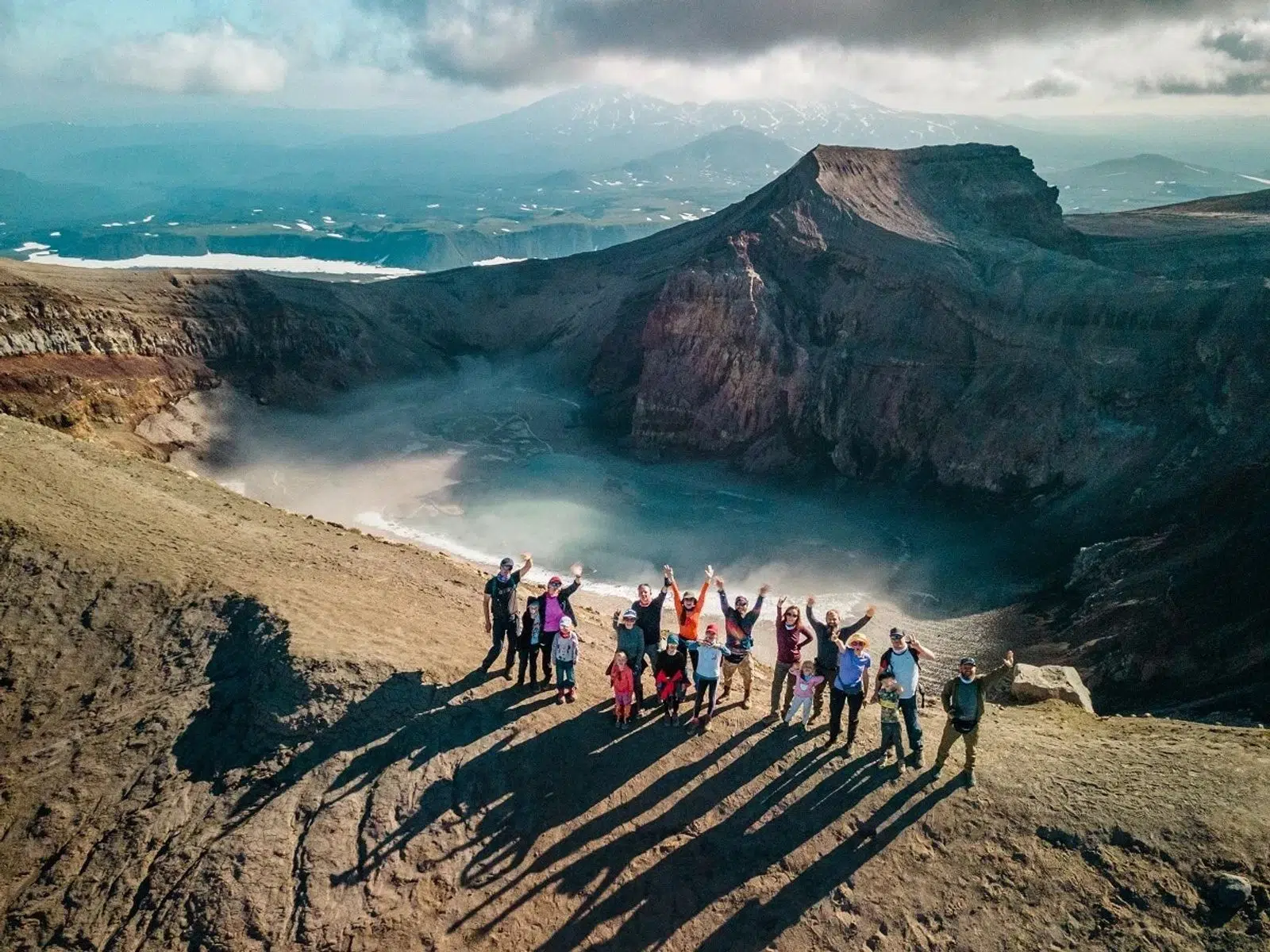 A group casting long shadows on the rim of Gorely Volcano