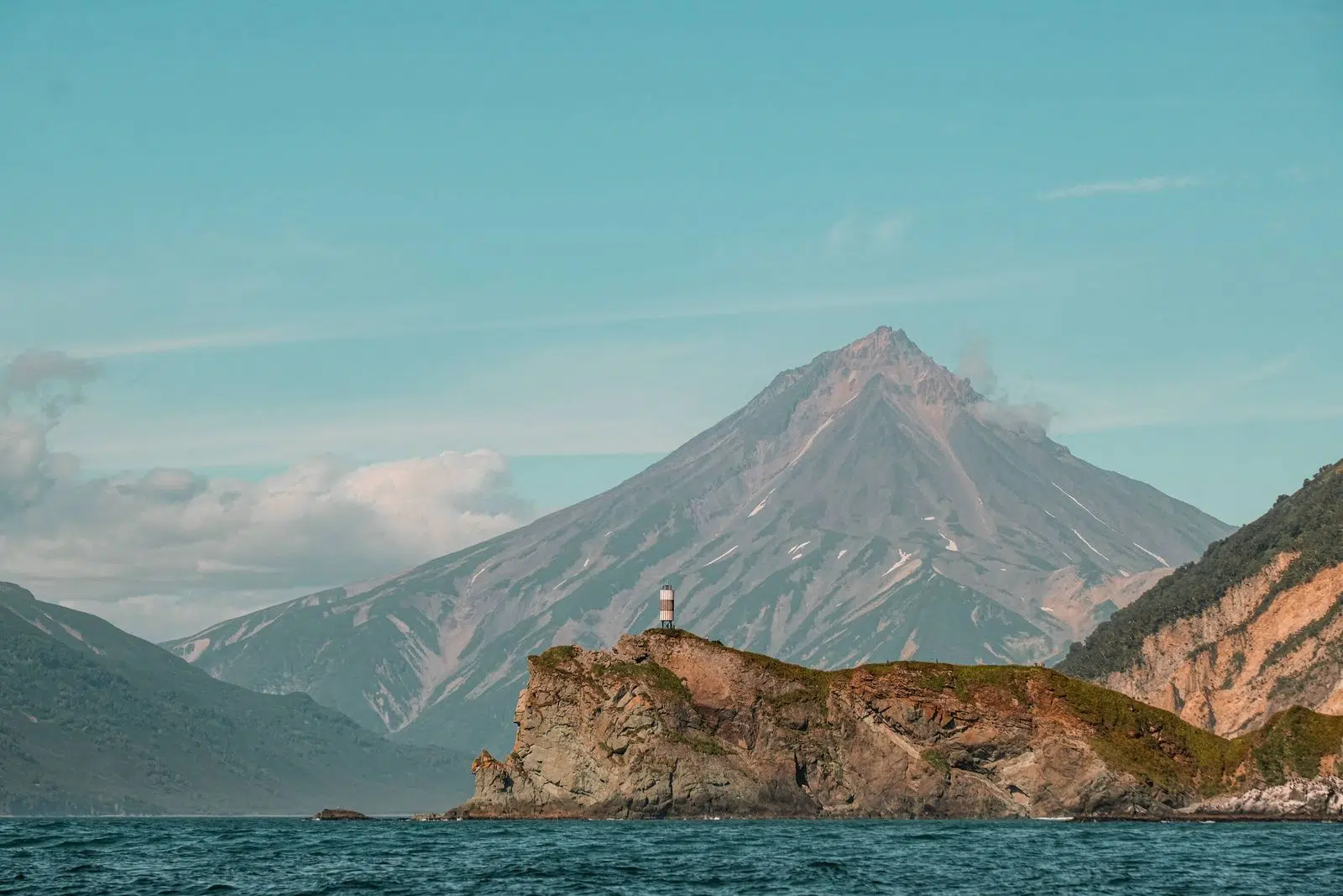 A volcanic peak and rocky island seen from the Pacific