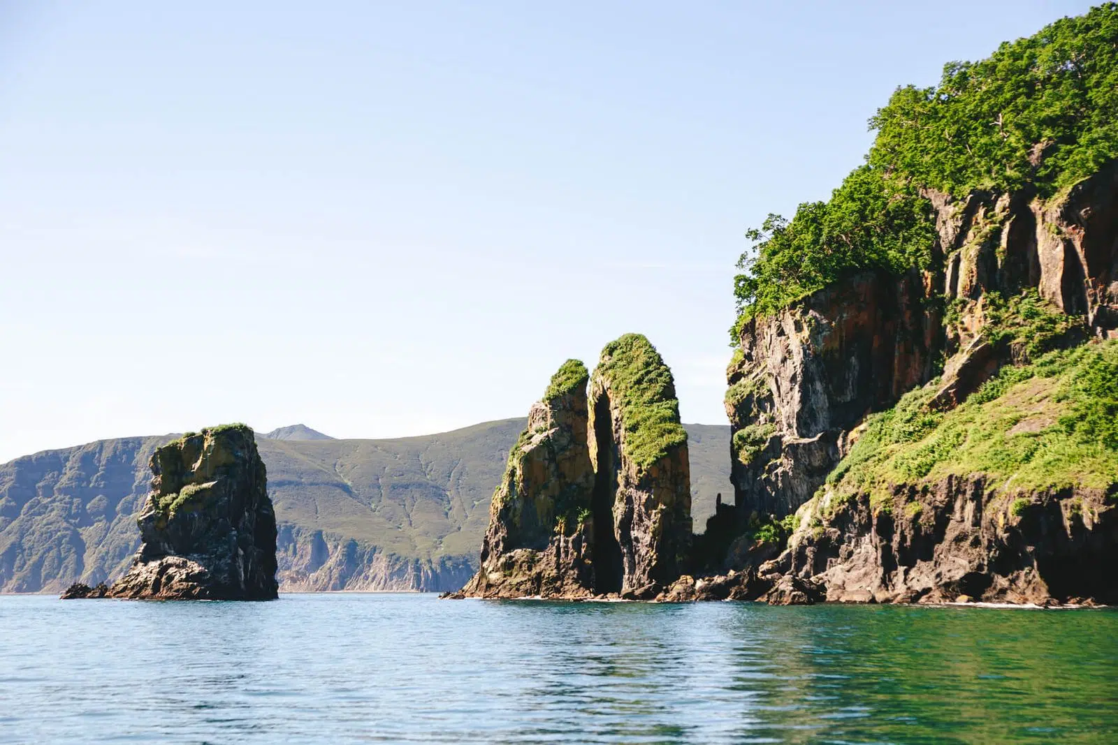 Green sea cliffs and rock pillars along the Kamchatka coast