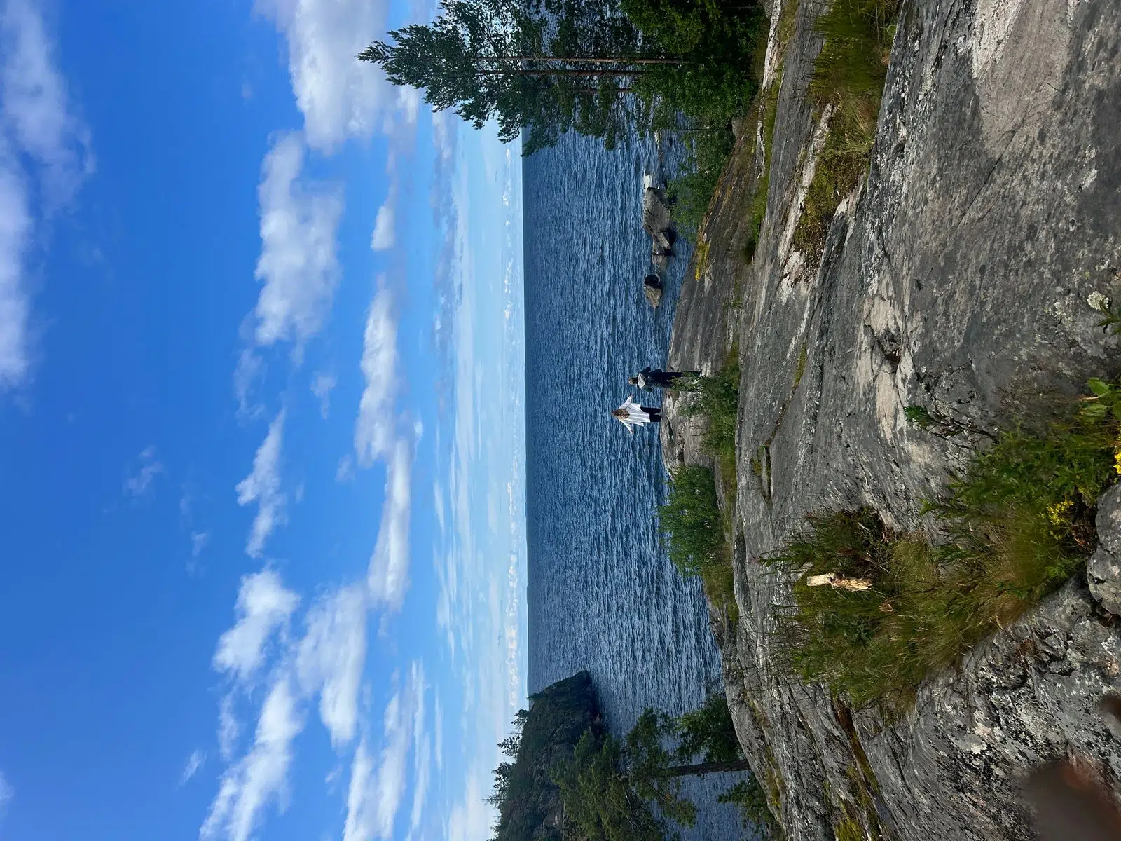Open view across a rocky Karelian lakeshore under summer clouds