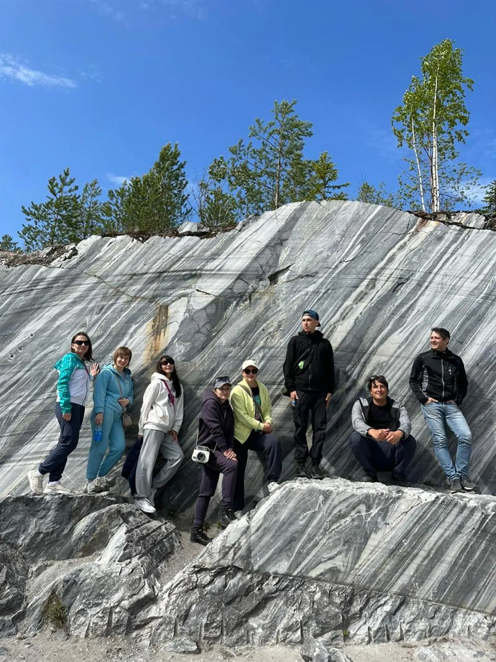 Tour group gathered on warm evening rocks above the water