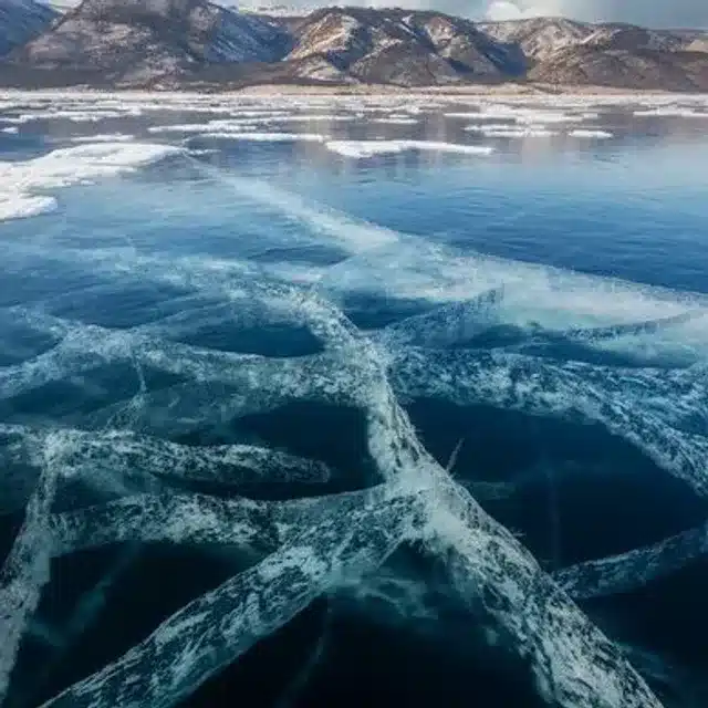 Clear blue Baikal ice crossed by broad white cracks