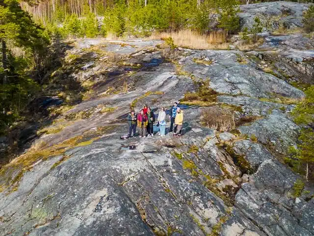 Small hiking group crossing exposed rock above the forest